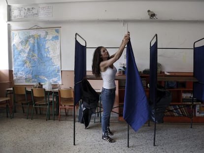 Una funcionaria coloca una cabina en un colegio en Atenas.