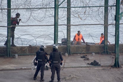 Según confirman fuentes oficiales, el número de personas que querían atravesar la frontera era mayor, pero solo ese grupo ha conseguido atravesar la doble valla que separa España y Marruecos. En la imagen, uno de los inmigrantes atrapados en la valla.