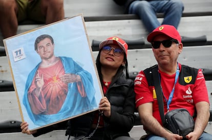 Dos aficionados mexicanos, vestidos de Ferrari, muestran una imagen alusiva a Checo Pérez, este domingo en el Gran Premio de México.