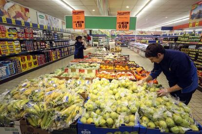 Dos empleados reponen la fruta en un supermercado de Madrid