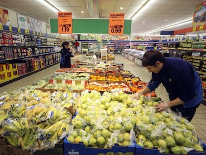 Dos empleados reponen la fruta en un supermercado de Madrid