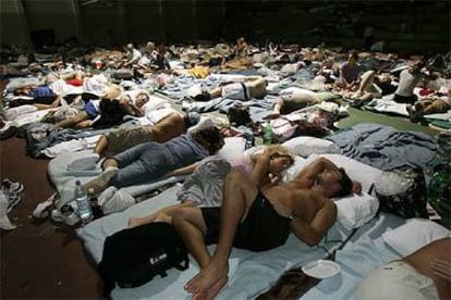 Turistas evacuados de sus hoteles ante la llegada del huracán Wilma duermen en un refugio provisional instalado en Cancún.
