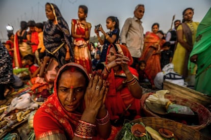 Um grupo de devotos indianos realiza rituais para venerar o pôr do sol nas águas do rio Sabarmati, em Ahmedabad (Índia). Esse festival tem como figura principal a deusa do poder, Chatti Mai, a quem se venera durante o amanhecer e o entardecer.