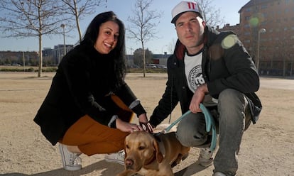 Lourdes Cañizares y Adrián Martínez con su perra en un parque frente a su vivienda de alquiler en el barrio madrileño de Vallecas.