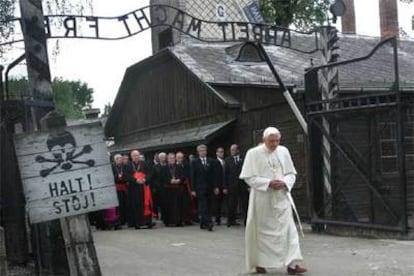 El Papa atraviesa la puerta del campo de concentración de Auschwitz, donde se lee en el letrero de la izquierda "¡Alto!" en polaco y en alemán.