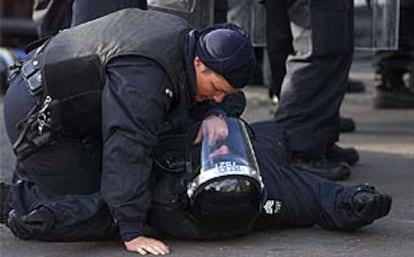 Un policía del Ulster ayuda a un compañero herido durante enfrentamientos con protestantes.