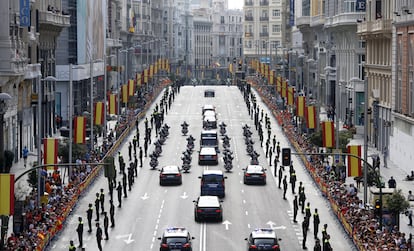 El coche con los Reyes de España sube la Gran Vía de Madrid.