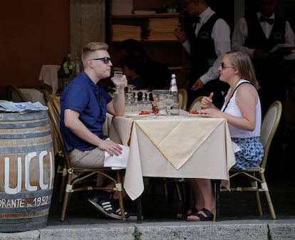 Dos turistas comen en la terraza de un restaurante del centro de Roma