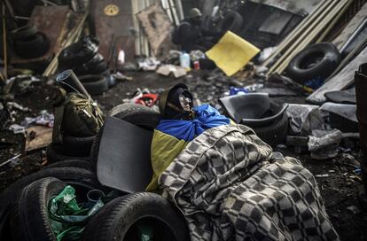 La restitución de la Carta Magna de 2004 es una de las principales demandas de la oposición ucraniana, que exige también la celebración de elecciones presidenciales anticipadas. En la imagen, un manifestante descansa en la plaza de la Independencia de Kiev, 21 de febrero de 2014.