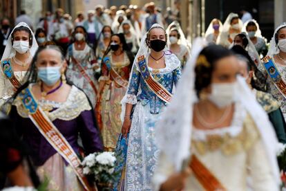 Cientos de falleras han desfilado por la plaza de la Virgen para cumplir con el tradicional y emotivo acto de ofrenda floral a la patrona, conocida cariñosamente como 'Geperudeta', con un nuevo recorrido para evitar las aglomeraciones, en filas de cuatro, distancia de seguridad y pertrechadas con mascarillas.