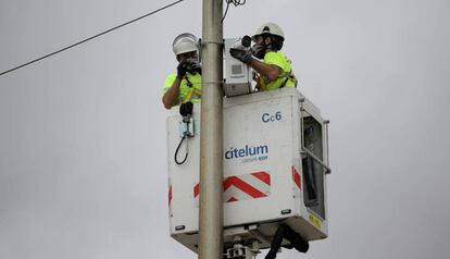 Uns operaris col·loquen càmeres a les platges de Barcelona, aquest dilluns.