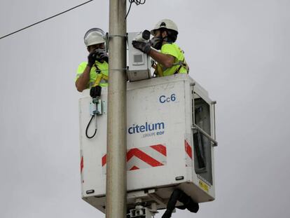 Uns operaris col·loquen càmeres a les platges de Barcelona, aquest dilluns.