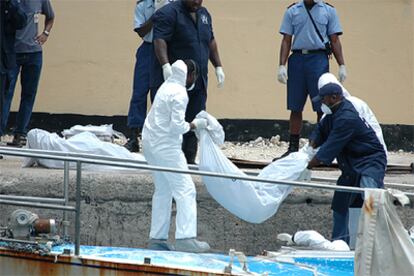 Agentes de las Bahamas trasladan al puerto los cadáveres de los inmigrantes africanos.