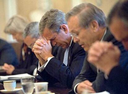 El presidente Bush, con el ex secretario de Defensa Donald Rumsfeld y otros miembros de su equipo, reza antes de iniciar una reunión tres días después del atentado del 11 de septiembre de 2001.