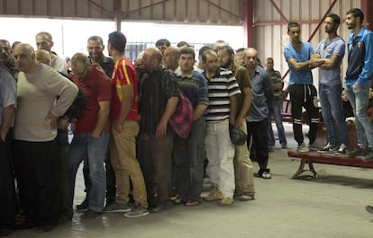 Fila de homens no posto de controle de Qalandiya.