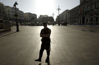 Un policía vigila esta mañana la Puerta del Sol, de donde ayer fueron desalojados los indignados.