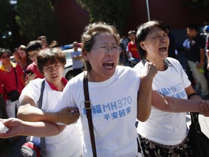 Familiares de los pasajeros del vuelo MH370 de Malaysia Airlines lloran durante una ceremonia en Pekín cuando se cumplen seis meses de la desaparición del avión.