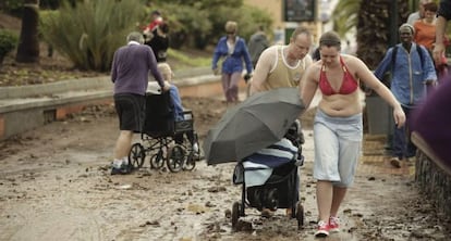 Unos turistas en Los Cristianos (Arona), tras un temporal en 2013.