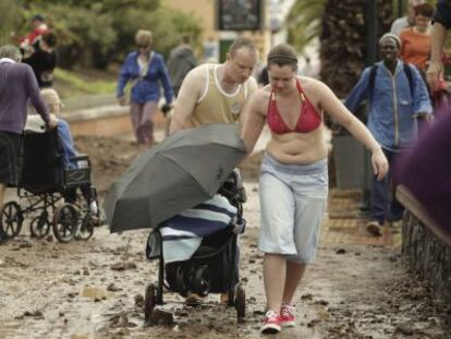 Unos turistas en Los Cristianos (Arona), tras un temporal en 2013.