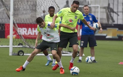 Oscar e Renato Augusto disputam a bola durante treino.