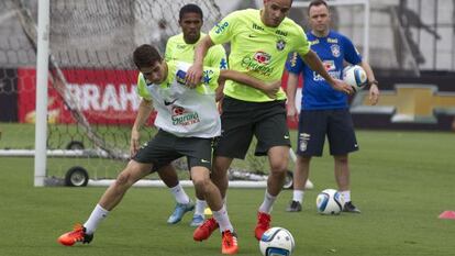 Oscar e Renato Augusto disputam a bola durante treino.