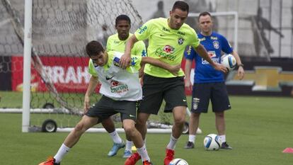 Oscar e Renato Augusto disputam a bola durante treino.