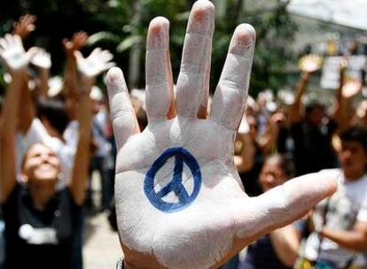 Un estudiante venezolano levanta su mano pintada de blanco con el símbolo de la paz para expresar su protesta por el cierre de RCTV