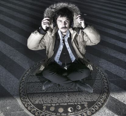 Paco Bezerra, sentado en la placa en el suelo de la plaza de la Luna que dice que allí hay un portal a la umbraesfera.