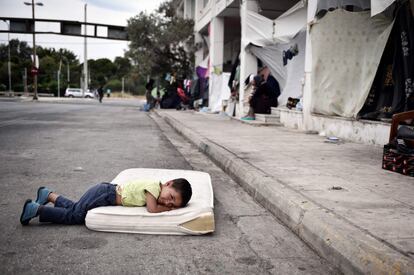 Un niño refugiado descansa en el campamento provisional situado en el antiguo aeropuerto de Atenas, en Grecia.