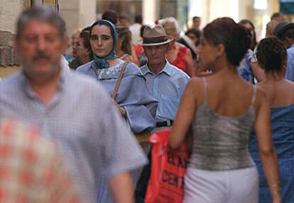 Una mujer con indumentaria magrebí camina por una de las calles comerciales de Málaga.