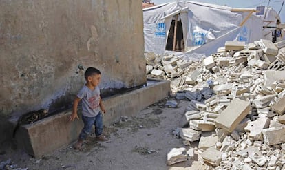Un niño refugiado sirio mira los escombros de una vivienda de hormigón tirado abajo en la ciudad de Rihaniyye, en Líbano.