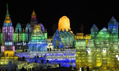 Luces de hielo iluminan la ciudad de hielo de Harbin, China. Visitantes recorriendo la instalación que se puede visitar durante todo este mes.