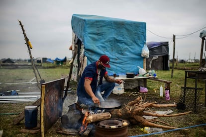 Sem-teto cozinha sob a intempérie, em Buenos Aires, em agosto de 2020.