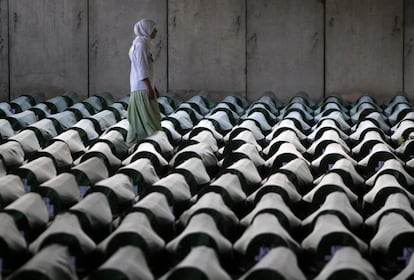 Una mujer bosnia camina entre los féretros de las 409 víctimas identificadas de la matanza musulmana en Srebrenica en el centro memorial de Potocari.