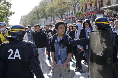 Efectivos de la policía antidisturbios tratan de detener a estudiantes franceses que protestan por la reciente decisión gubernamental de deportar a una niña kosovar de etnia gitana, en una manifestación en París (Francia), 17 de octubre de 2013. 