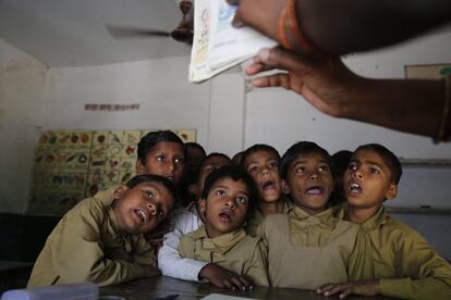 Un grupo de alumnos escuchan a su profesor en una escuela de Allahabad, India.