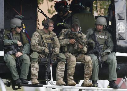 Police officers prepare to take off in a helicopter for a manhunt in Fox Lake, Illinois, United States, September 1, 2015.  Police with dogs and helicopters are searching woods and swampy areas north of Chicago for three armed suspects after a police officer was shot dead on Tuesday in the suburb of Fox Lake, a local law enforcement official said.  REUTERS/Jim Young        TPX IMAGES OF THE DAY     