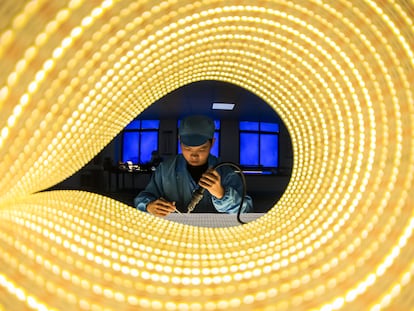 Un empleado trabaja en la línea de producción de tiras de luces LED en una empresa de la provincia china de Jiangxi.