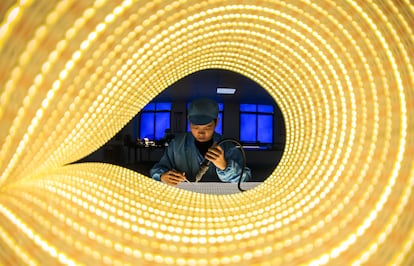 Un empleado trabaja en la línea de producción de tiras de luces LED en una empresa de la provincia china de Jiangxi.