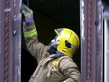 Un bombero inspecciona los daños ocasionados en una vivienda próxima al lugar donde explosionó el coche bomba.