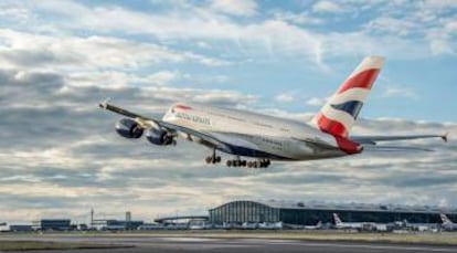 Un avión de British Airways toma tierra en el aeropuerto londinense de Heathrow, con la terminal 5 de fondo.