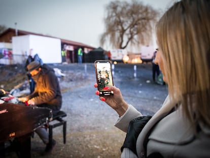 Una joven graba con su teléfono a Davide Martello, pianista alemán de origen italiano, que toca todos los días durante varias horas para dar la bienvenida a los refugiados que acaban de cruzar la frontera desde Ucrania.