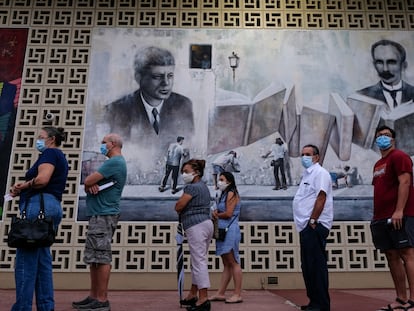 La gente hace fila en la mesa de votación de la Biblioteca John F. Kennedy, en el inicio de la votación anticipada en Hialeah, Florida, el 19 de octubre de 2020.