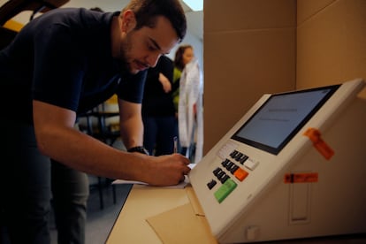 Un empleado de Justicia Electoral prepara una mesa de votación durante las elecciones legislativas y presidenciales, en São Paulo