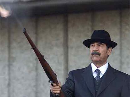 Sadam Husein dispara un fusil al aire durante un desfile militar en 2000.