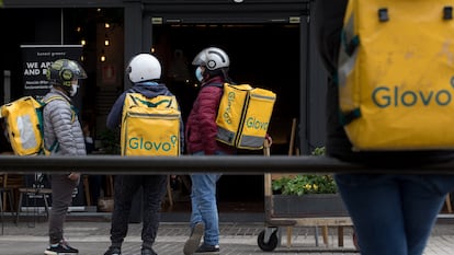 Unos 'riders' esperan para recibir su pedido en la zona de Azca de Madrid, este miércoles.