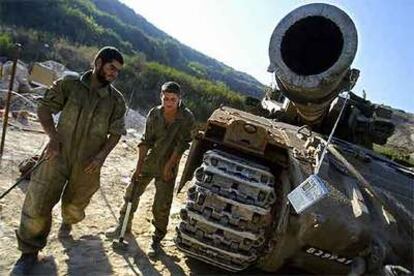 Dos soldados reparan un carro de combate al norte de Israel.
