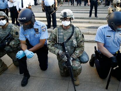Philadelphia police and Pennsylvania National Guard take a knee at the suggestion of Philadelphia Police Deputy Commissioner Melvin Singleton, unseen, outside Philadelphia Police headquarters in Philadelphia, Monday, June 1, 2020 during a march calling for justice over the death of George Floyd, Floyd died after being restrained by Minneapolis police officers on May 25. (AP Photo/Matt Rourke)