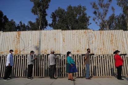 Votantes hacen fila para ingresar a un centro electoral hoy, en el distrito de Villa El Salvador, en Lima.