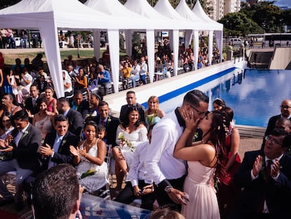 Unos novios se besan tras casarse en una boda colectiva de la alcaldía de Chacao en Caracas (Venezuela), este 14 de febrero.